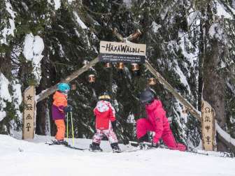 Two children and a woman at the entrance to the adventure slope on Flumserberg