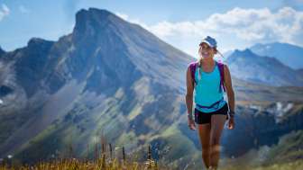 Young woman in summer clothing hikes on the 7-summit tour on the Flumserberg
