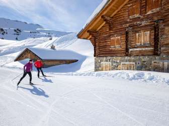 Two cross-country skiers on the Flumserberg in front of a hut