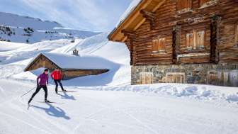 Two cross-country skiers on the Flumserberg in front of a hut